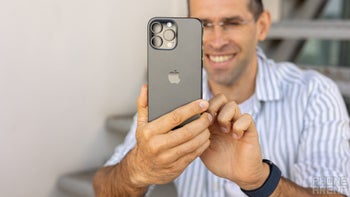 A person holding an iPhone 16 Pro Max in his hands and smiling.