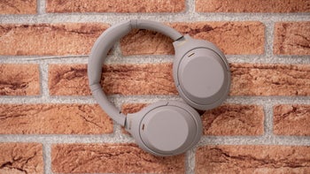 Sony WH-1000XM4, placed on a textured brick background.