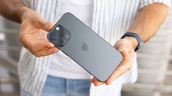 Two hands holding iPhone 16 Pro Max; back facing camera.