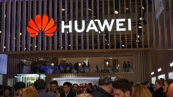 A Huawei sign including the dompany logo lights up on a building.