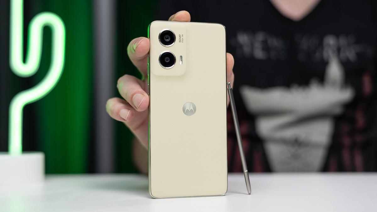 A person holding the Moto G Stylus 5G (2024) alongside the built-in stylus, showcasing the rear camera module.