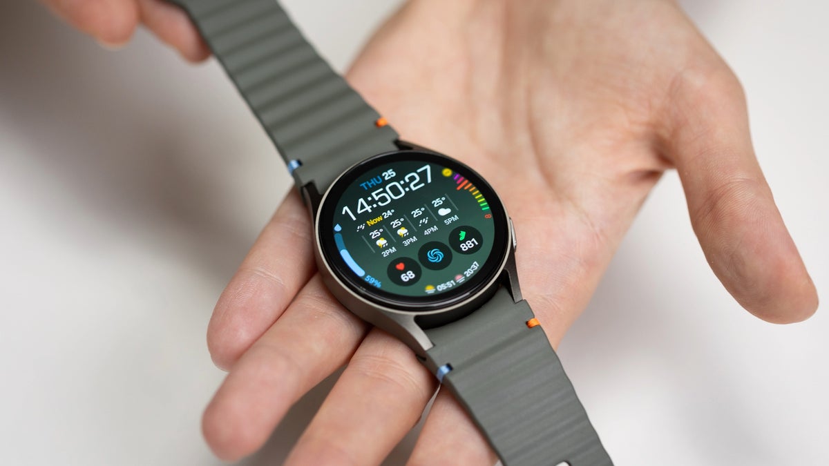 A person's hand holding a Samsung Galaxy Watch 7 smartwatch.