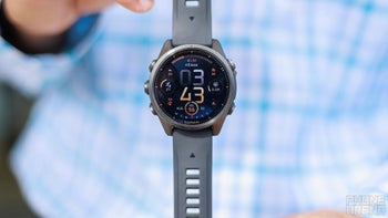 A person holding a Garmin Fenix 8 smartwatch.