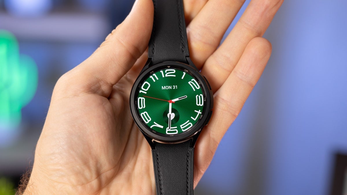 A person holding a Galaxy Watch 6 Classic