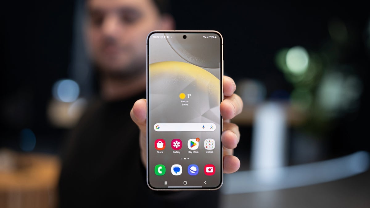 A Galaxy phone held up by a person facing the viewer.