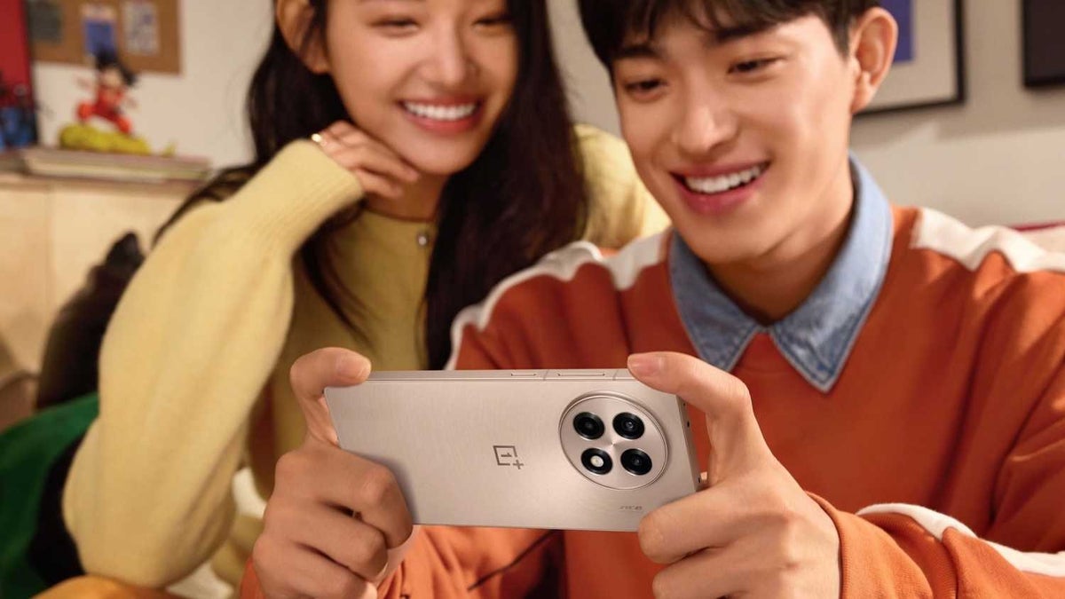 Two people looking into a OnePlus Ace 5 phone in Gold color.