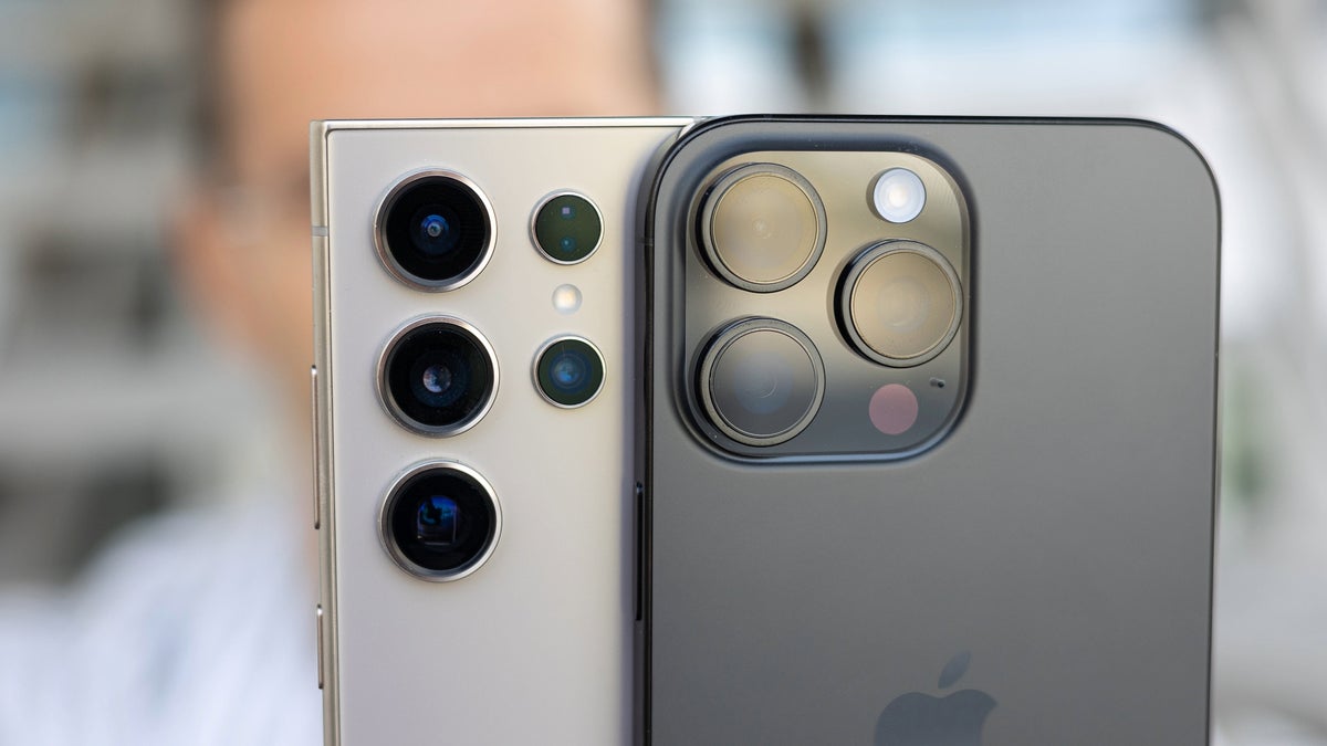A person holding the iPhone 16 Pro Max and Samsung Galaxy S24 Ultra.