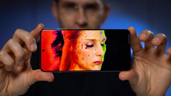 Close-up of a OnePlus 13 smartphone displaying vibrant, colorful artwork on its high-resolution screen.