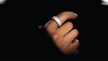 A person wearing a smart ring on their finger.