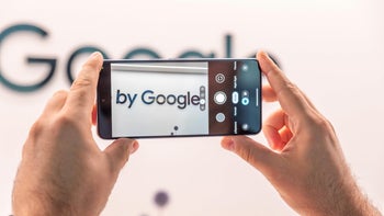 A phone taking a photo of "By Google"'s logo on a wall.