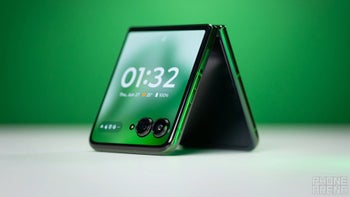 A green Motorola Razr Plus (2024) positioned on the top of a table.