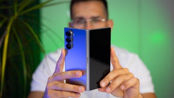 The Galaxy Z Fold 6 partially open and held by PhoneArena's Vic with the rear of the phone facing the camera.