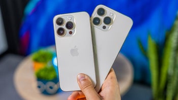 The rear panels of the iPhone 14 Pro and iPhone 14 Pro Max are held in someone;s right hand.