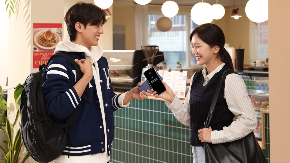 Two people holding their smartphones next to each other.