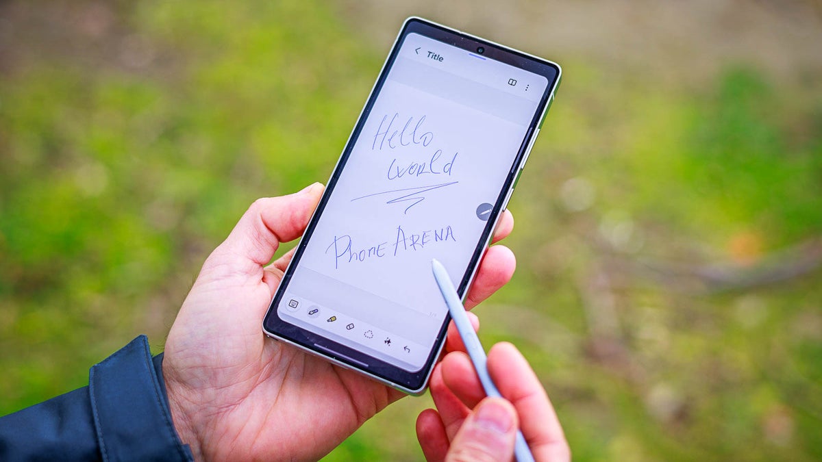 Man holding a phone and a stylus, with hand-written words as a note.