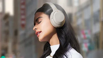 A woman wearing a pair of Sony WH-1000XM4 headphones.