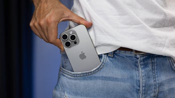 An iPhone 16 Pro being pulled out of a person's pocket.