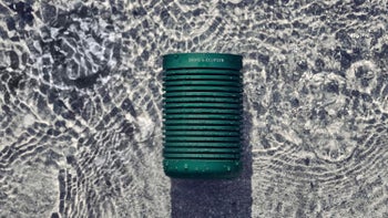 A close-up of the Beosound Explore speaker in water.