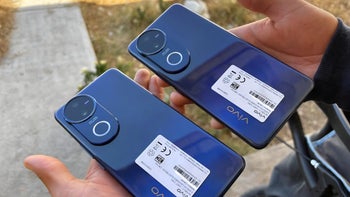 Hands holding two identical blue phones.