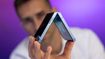 The Galaxy Z Flip 6 in its half-folded state looked at by a person.