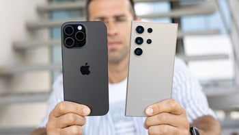 A man holding the Galaxy S24 Ultra and the iPhone 16 Pro.