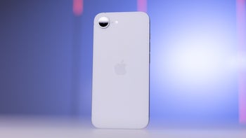 iPhone 16e on a white table, showcasing its back design and single rear camera.