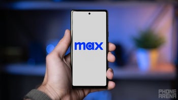 A hand holding a smartphone displaying the "Max" logo on a white screen.