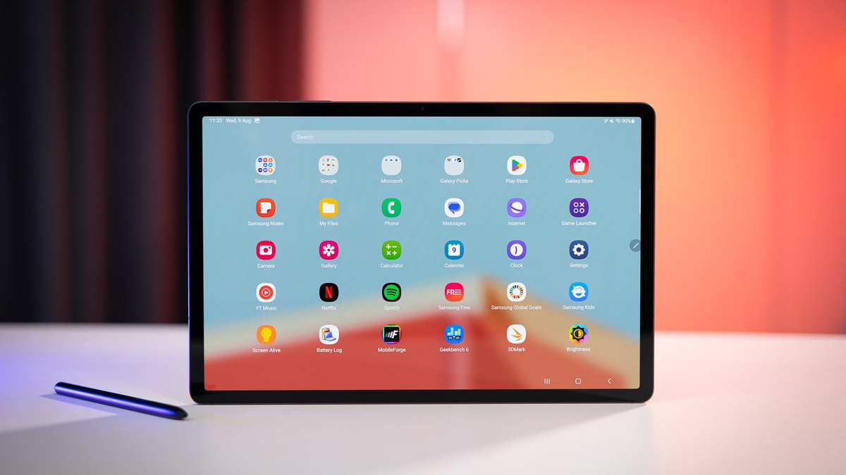 A Galaxy Tab S9 Plus tablet on a white table, showing different app icons and vibrant colors on its display.