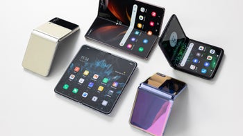 Five foldable smartphones from different brands are arranged on a white surface, showcasing various designs and screen displays.