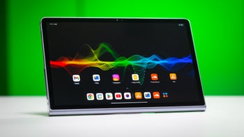 Lenovo Tab Plus on a white table against a green background.