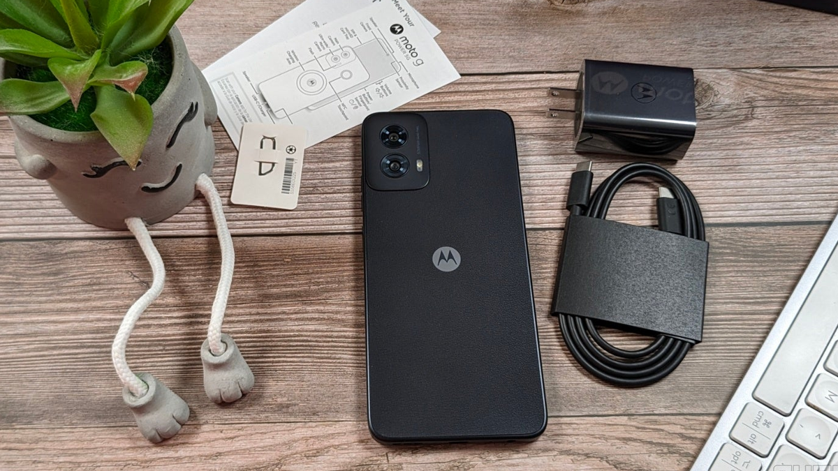 Moto G Power 5G (2024) with welcome guides, cables and sim ejection pin on a table.