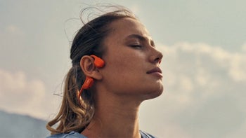 Image of a person wearing orange wireless headphones.