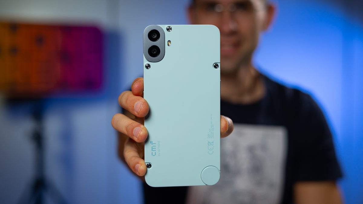 A person holding a light blue CMF Phone (1) showcasing its camera setup.