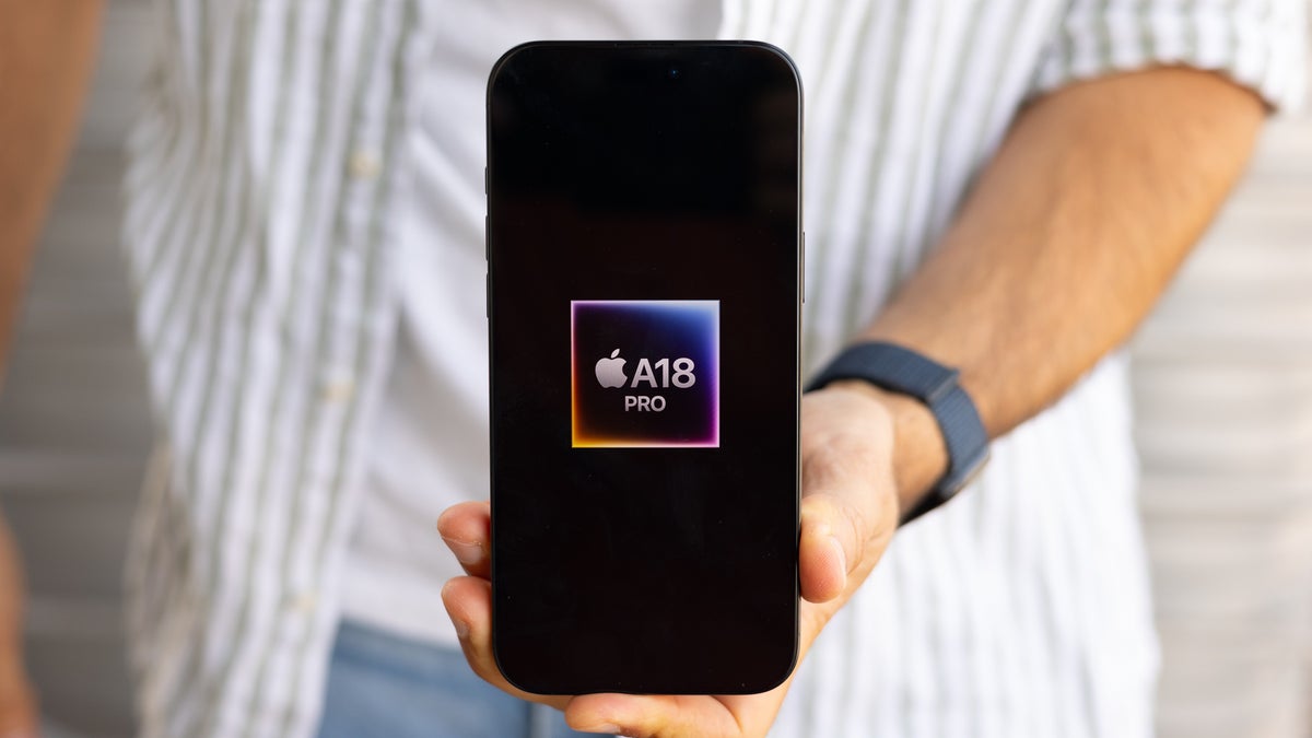 Hand holding phone with chip displayed on its screen.