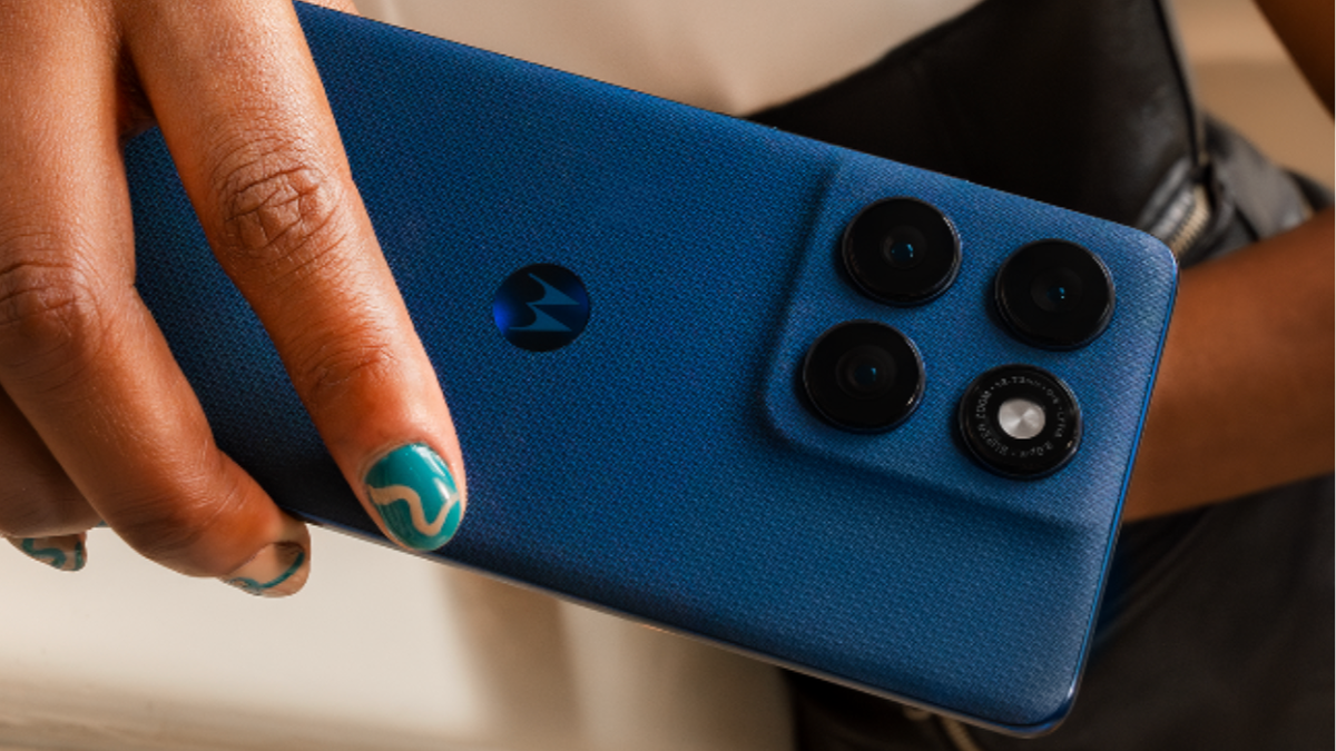 A photo of a hand holding a Moto Edge 60 in blue color.