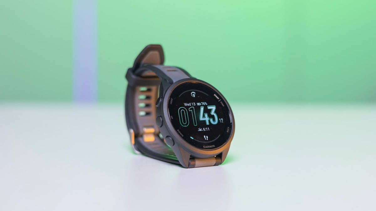 Garmin Forerunner 165 on a white table against a green background.