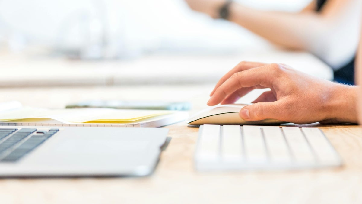 Image of a person using a Magic Mouse with a MacBook