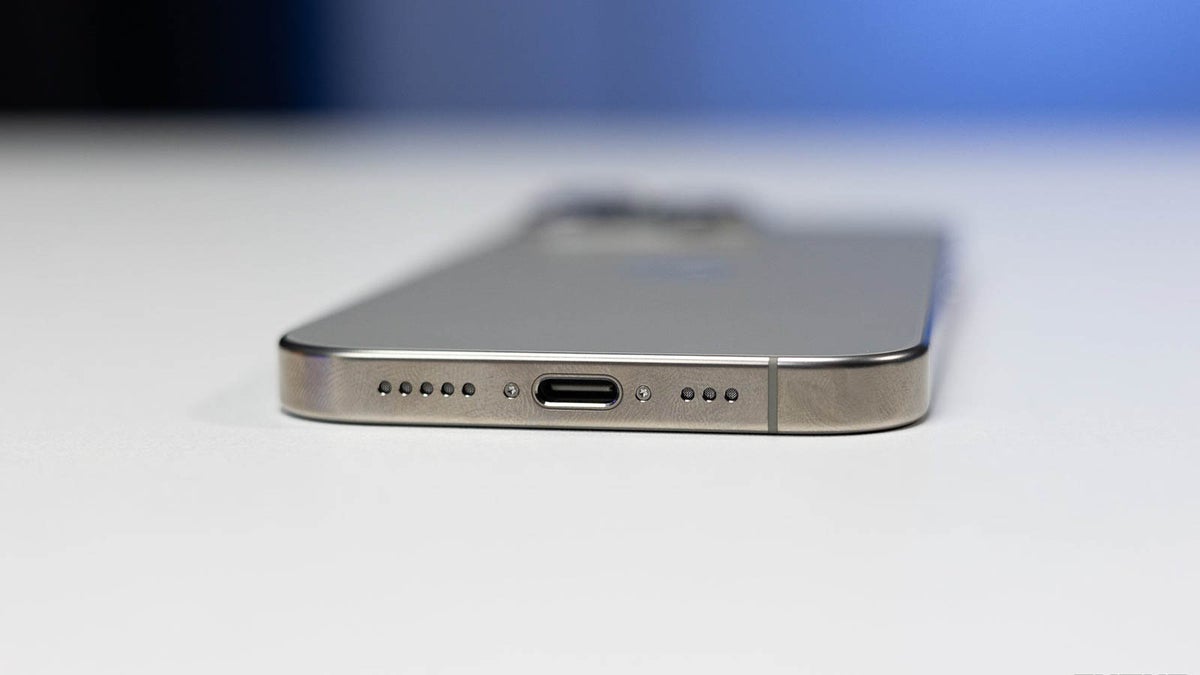 Phone laying on a table face down, with bottom part facing the camera.