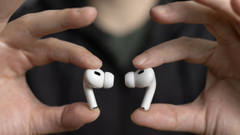 A person holds the AirPods Pro 2 with their index finger and thumb, highlighting their compact design.
