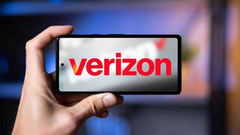 A hand holding a smartphone with Verizon's logo on the display.