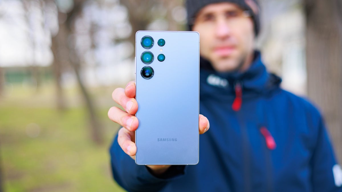 A person holds the Galaxy S25 Ultra in their hand, showcasing its rear quad camera setup.