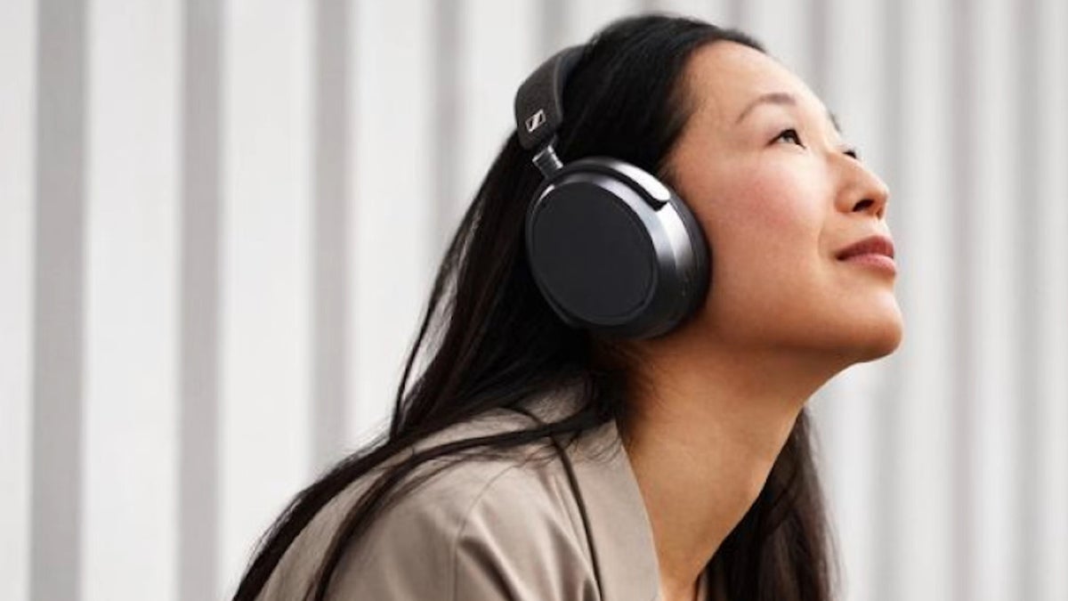 A woman wearing a set of Sennheiser Momentum 4.