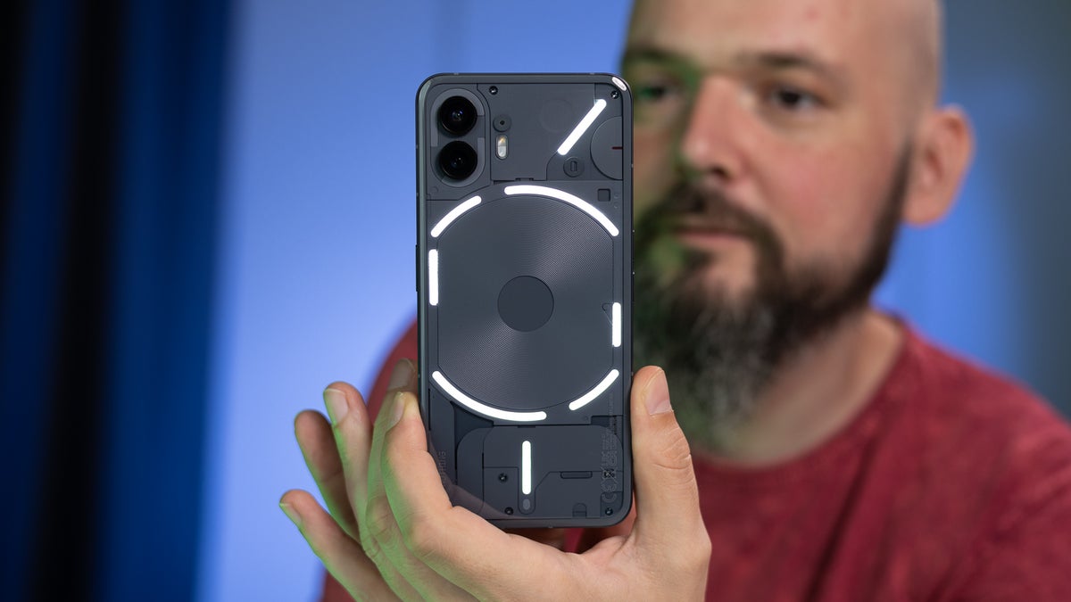 A person holding the Nothing Phone (2) in their hands.