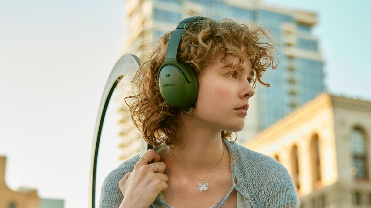 A close-up of a woman wearing a pair of Bose QuietComfort headphones.