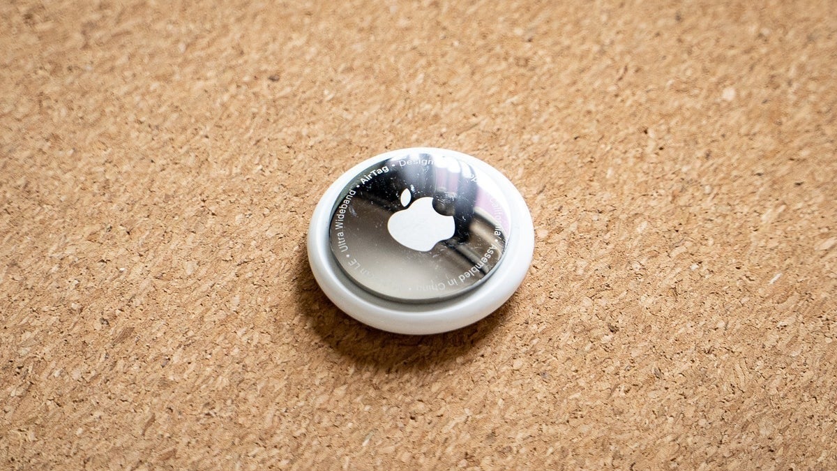AirTag laid down on a wooden surface.