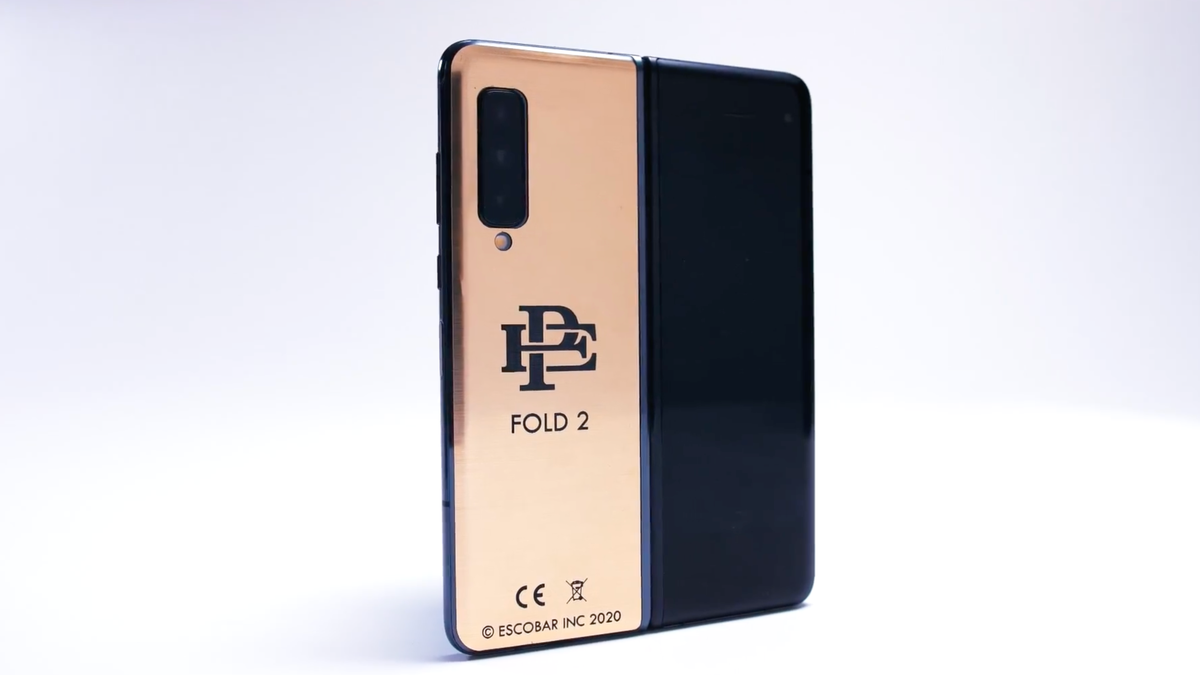 A foldable phone with golden finish on a white surface.