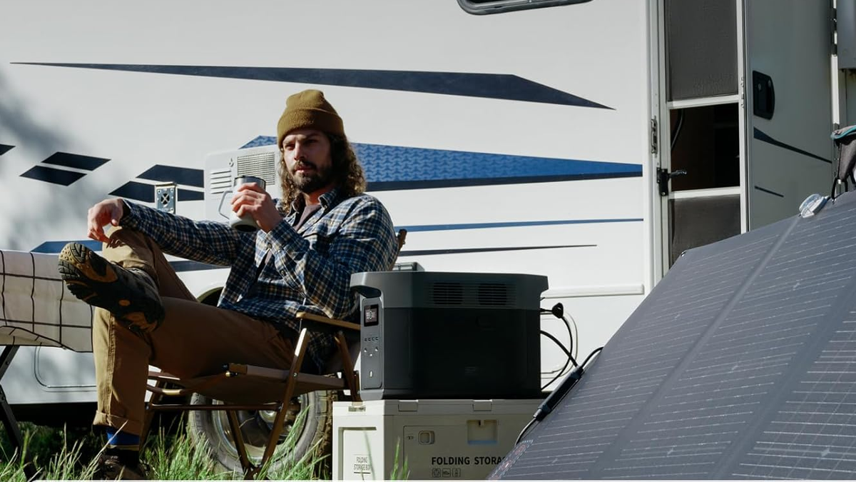 EcoFlow Delta 2 Max power station in an outdoor environment, with a person holding a cup visible in the background.