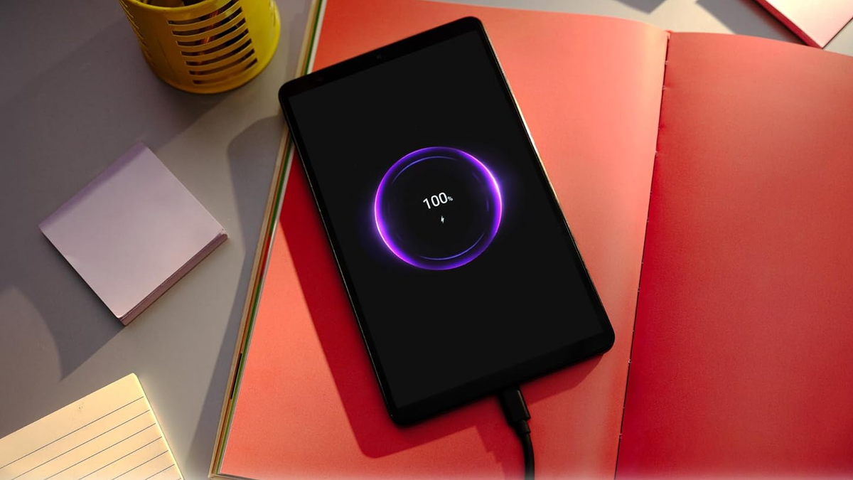Lenovo Tab One is placed on a book while charging.