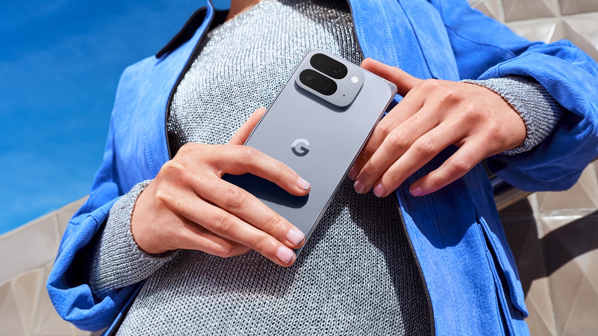 A person holding the Pixel 10 Pro Fold in Moonstone finish, showcasing its sleek design in a lifestyle setting.
