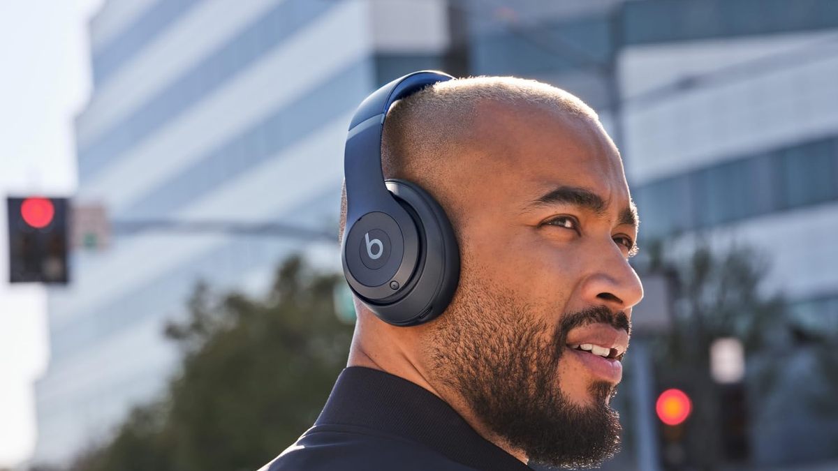 A person wears the Beats Studio Pro in an outdoor setting.